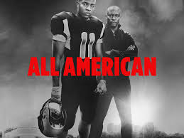 "Promotional poster for the TV series 'All American' (2018), featuring a young Black football player in a red and blue jersey standing on a football field, looking determined. The backdrop shows a suburban neighborhood and a city skyline, representing the show's themes of ambition, community, and overcoming challenges."