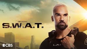 "The S.W.A.T. team stands in tactical gear against a fiery backdrop. Samuel L. Jackson as Hondo points forward authoritatively, flanked by Colin Farrell gripping a rifle and Michelle Rodriguez adjusting her helmet. Explosions light up the Los Angeles skyline behind them with the tagline: 'One team. One mission. No mercy.'"