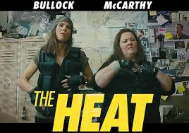 "Sandra Bullock and Melissa McCarthy stand back-to-back in police gear. Bullock as poised Agent Ashburn adjusts her sleek FBI vest, while McCarthy as disheveled Detective Mullins munches a donut, her Boston PD badge dangling crookedly. A flaming cop car explodes behind them with the tagline: 'Good cop. Mad cop.'"