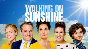 *"A sun-drenched collage of smiling actors dancing on a sandy beach, with the title 'Walking on Sunshine' in bold yellow letters against a bright blue sky. The energetic poster features couples in colorful 1980s outfits, with a sparkling ocean and disco ball graphics emphasizing the film's musical romance theme."*