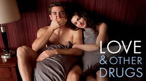 Jake Gyllenhaal and Anne Hathaway embrace intimately in a dramatic scene from 'Love & Other Drugs,' a romantic comedy-drama about a pharmaceutical salesman and an artist navigating love, illness, and ambition."